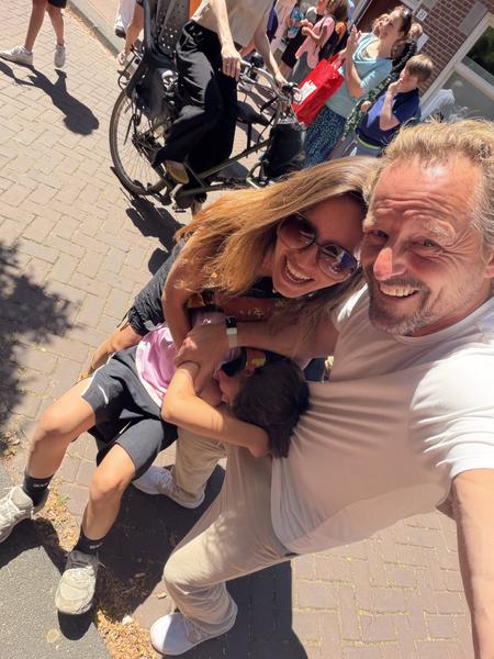 A family is captured in a joyful selfie on a sunny day in Nieuwe Batavierstraat, Uilenburg, Amsterdam